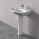 Waschtisch mit weißer, runder Schale und chromfarbener Armatur. Steht auf einem vertikalen, weißen Standfuß. Ideal Standard Design vor hellem Hintergrund.